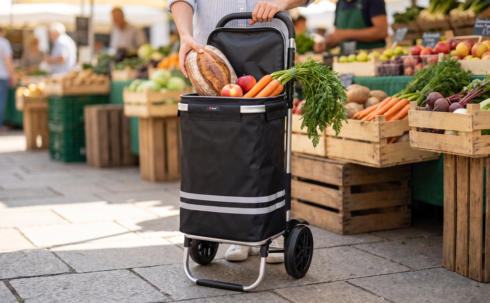 Ezzyrol 74L 2-wheel folding shopping trolley in black loaded with vegetables and bread at a market stall