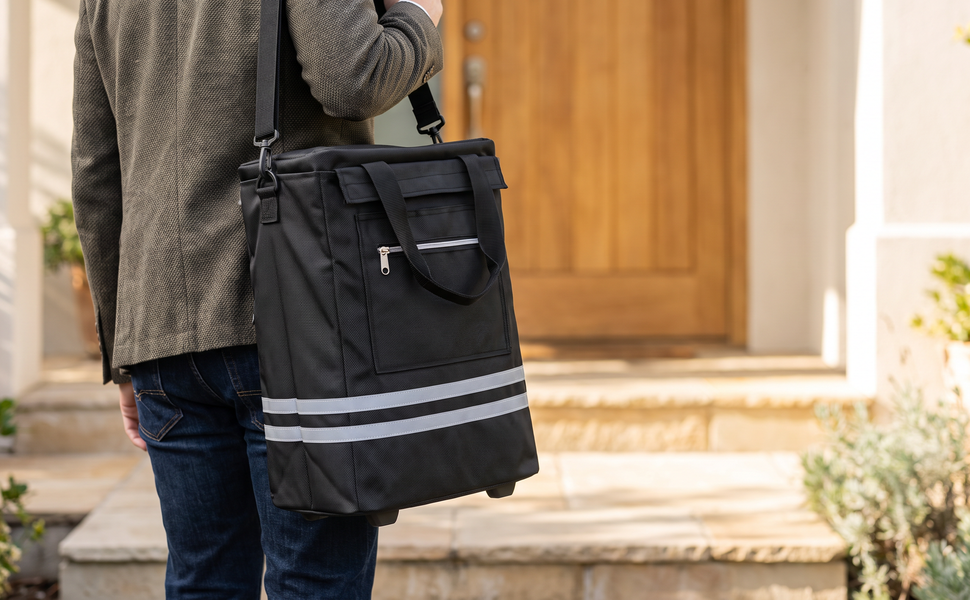 The removable bag of the black Ezzyrol 74L trolley carried by its shoulder strap at a front door