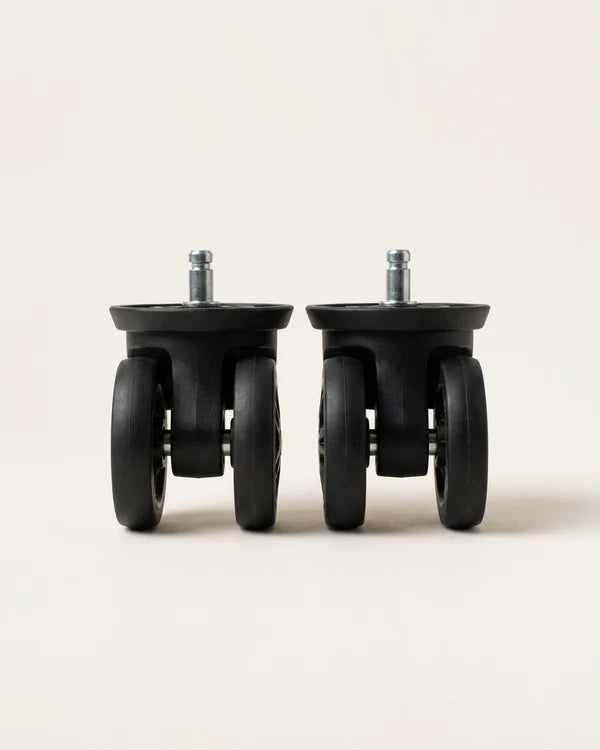 A pair of black double spinner replacement suitcase wheels