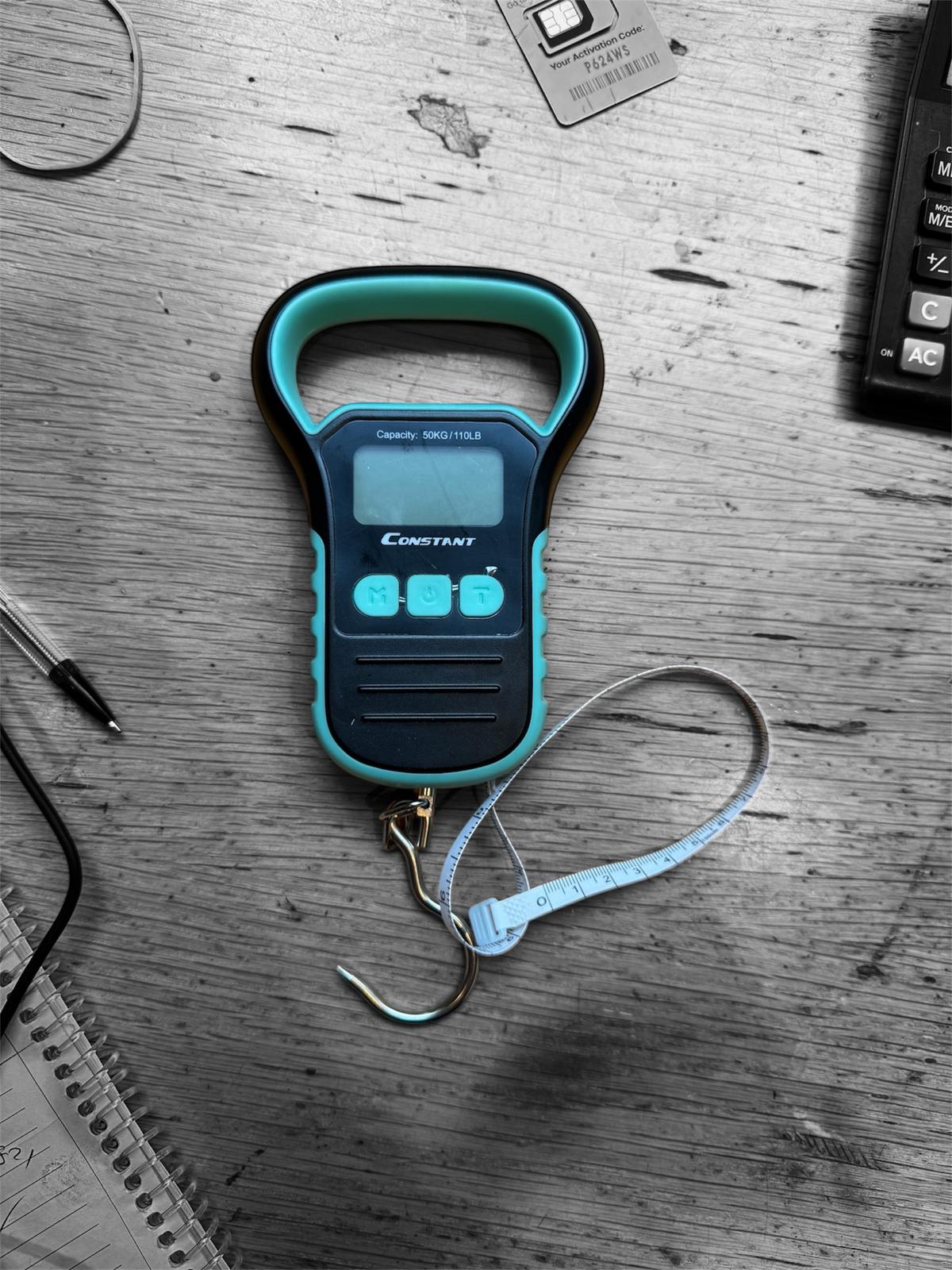 Constant electronic hanging luggage scale lying on a wooden desk