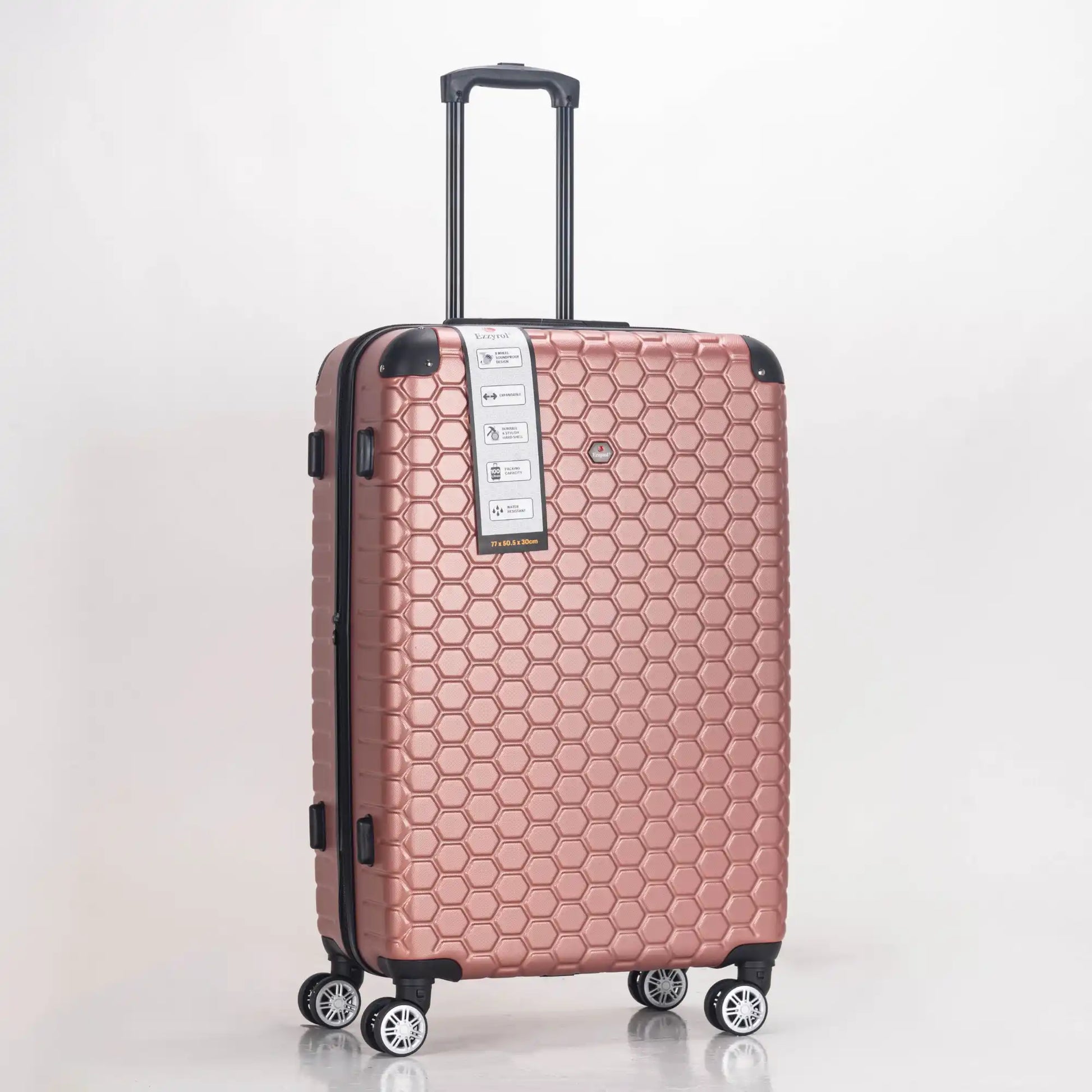 Rose gold suitcase with honeycomb pattern on a light gray background