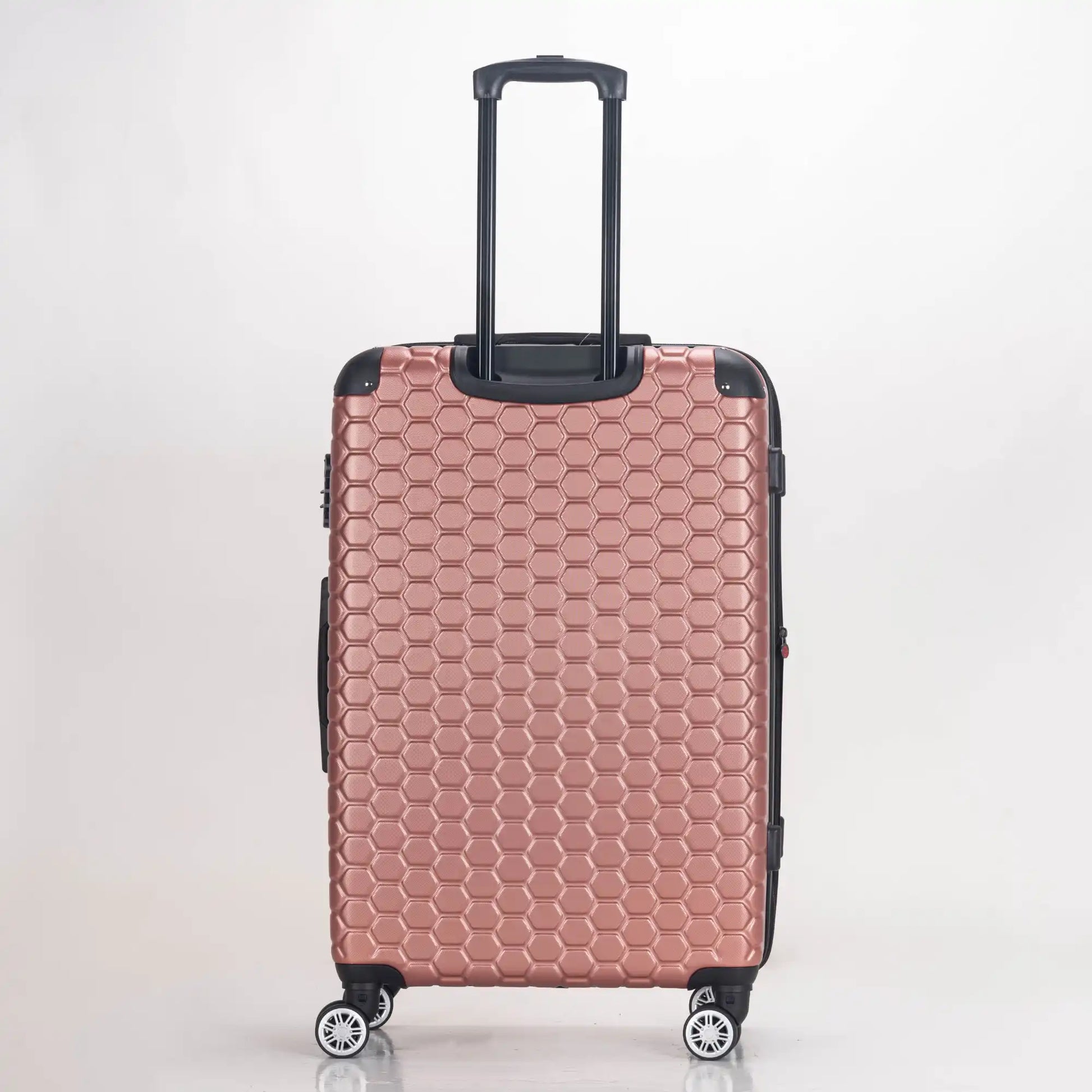 Rose gold honeycomb patterned suitcase on a white background