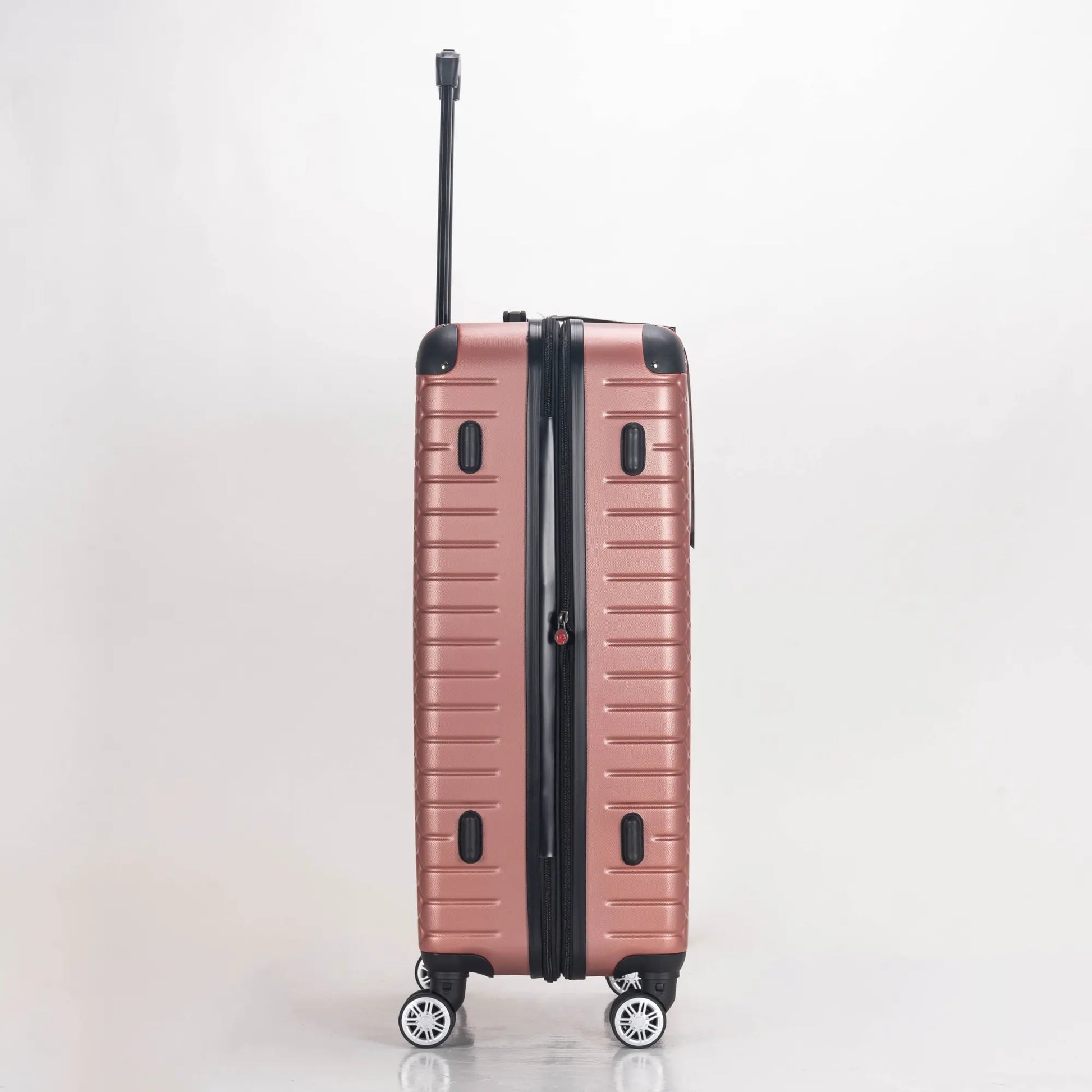 Rose gold suitcase with black handle and wheels on a light gray background