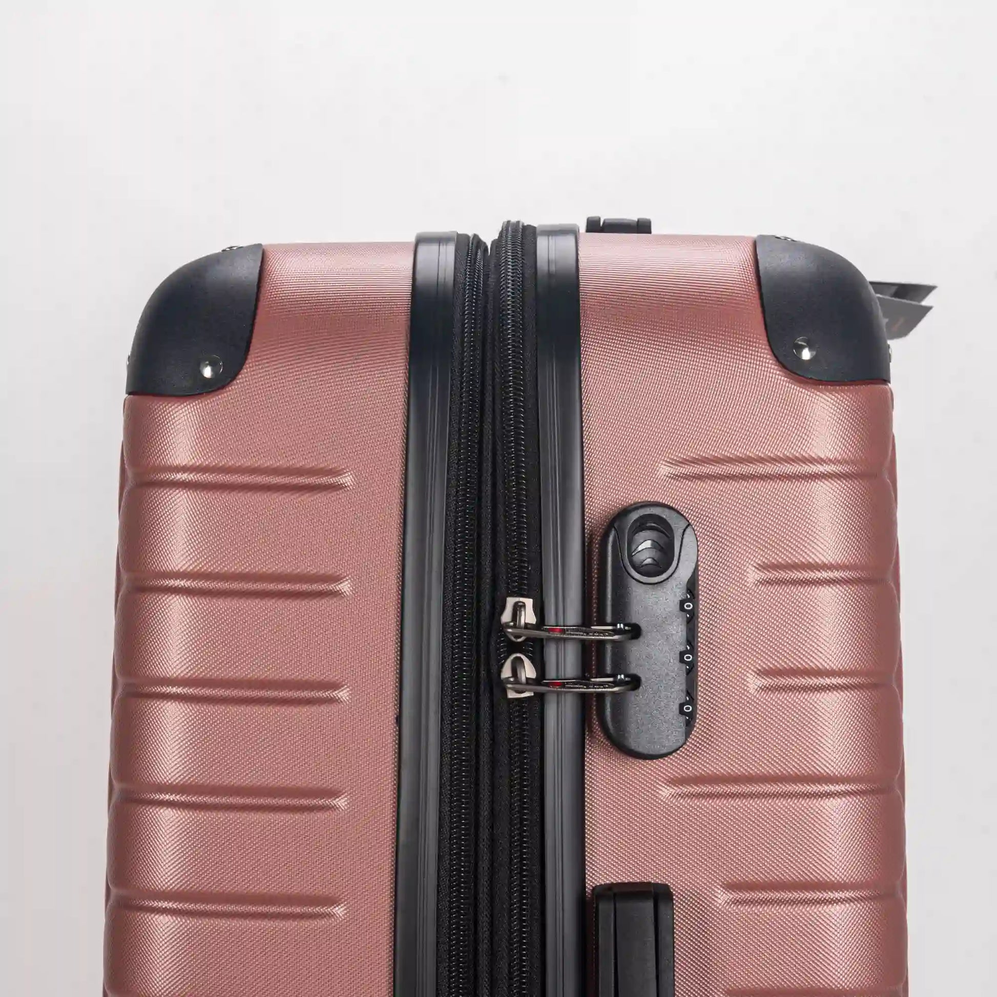 Rose gold suitcase with black handle and wheel on a light gray background