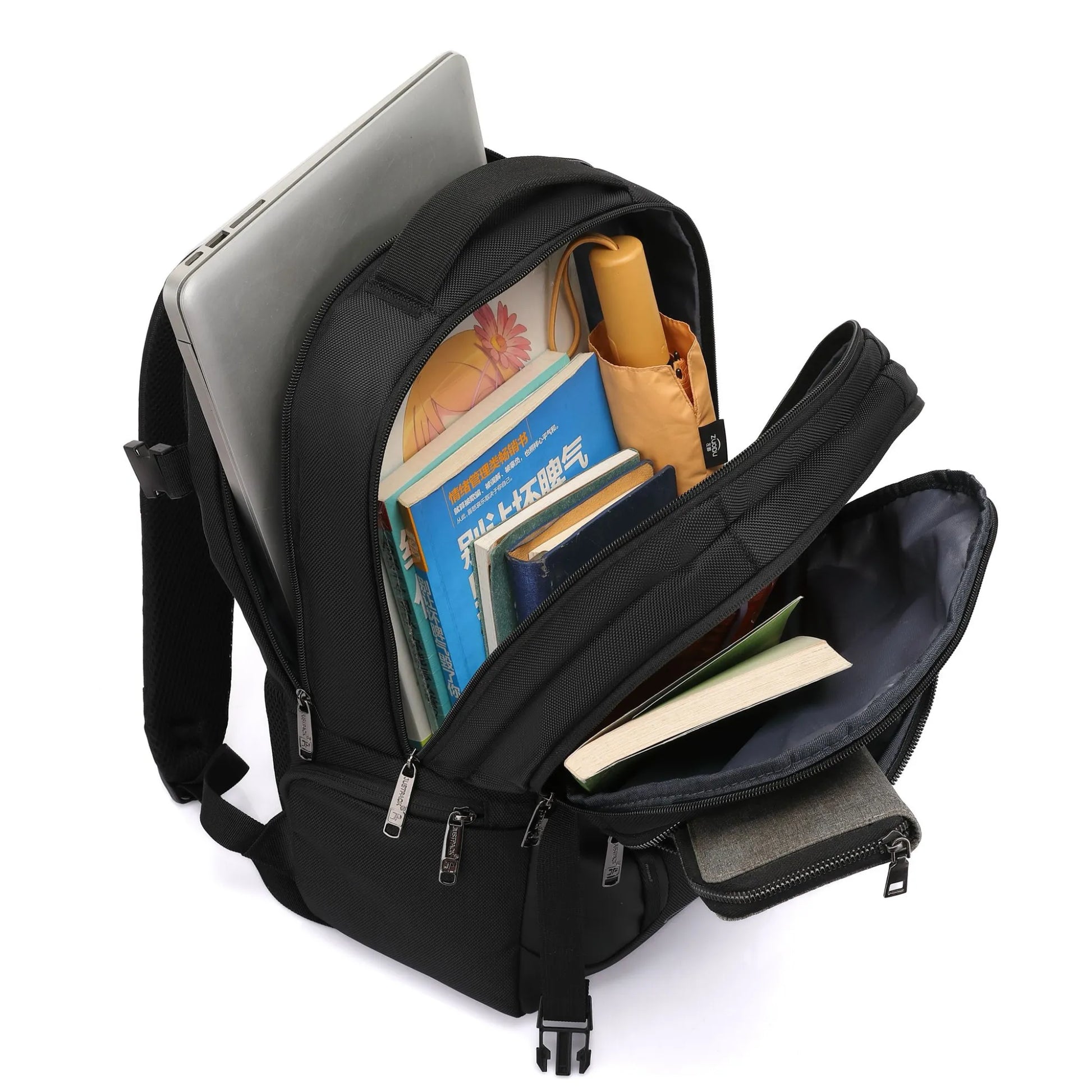 Black backpack with books and a laptop on a white background