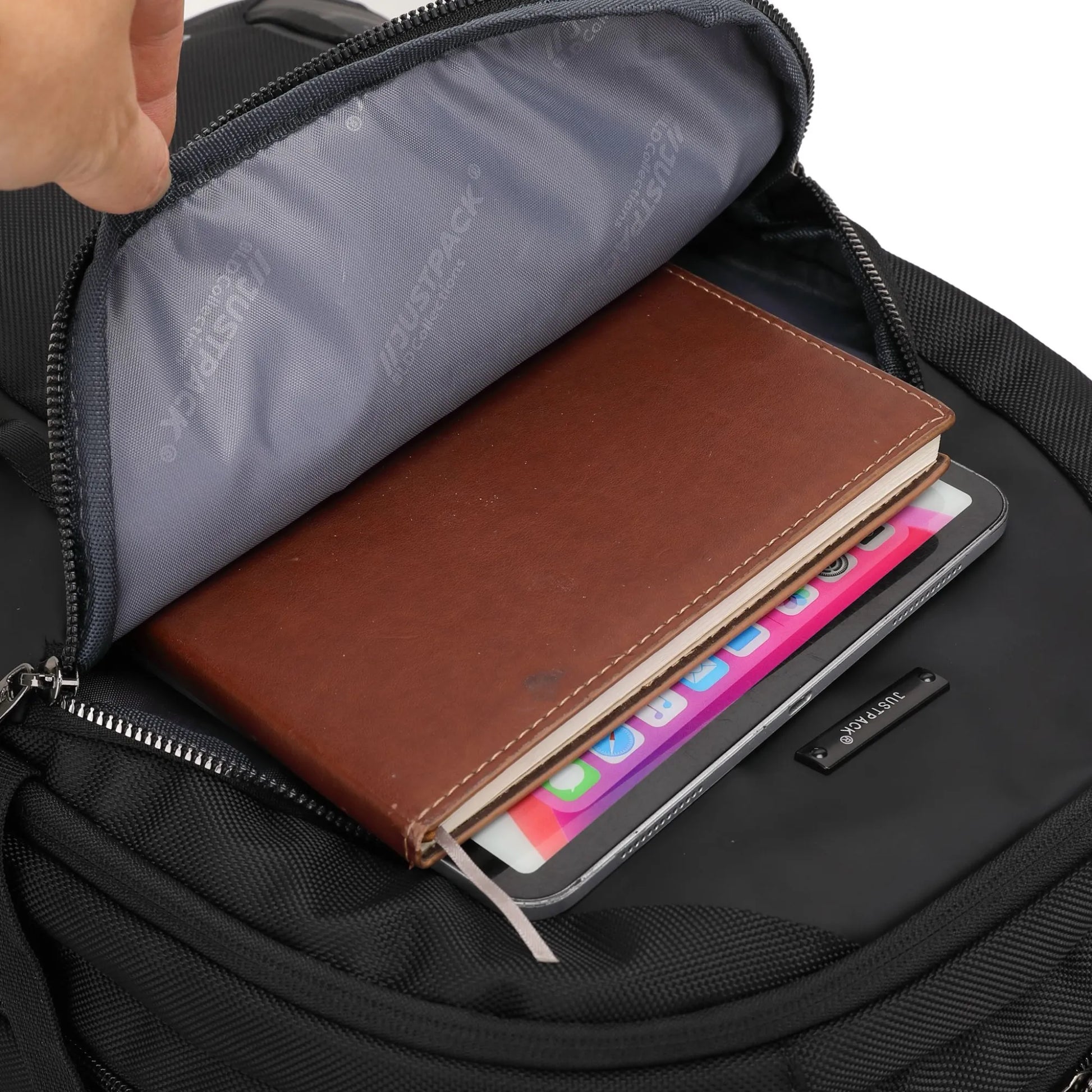 Black backpack with a brown leather notebook and colorful tablet inside, featuring the brand 'Tessl'.