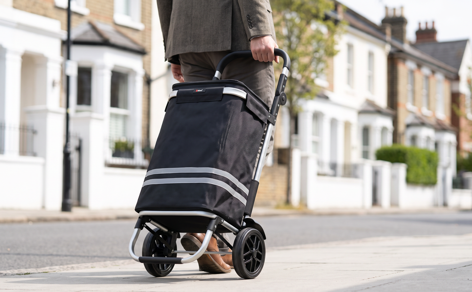 Ezzyrol 74L 2-wheel folding shopping trolley in black being pulled along a residential street