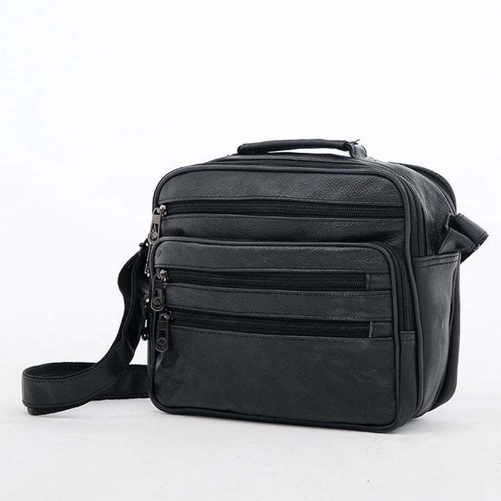 Black faux leather shoulder bag with a webbing strap, angled view showing the twin front zip pockets