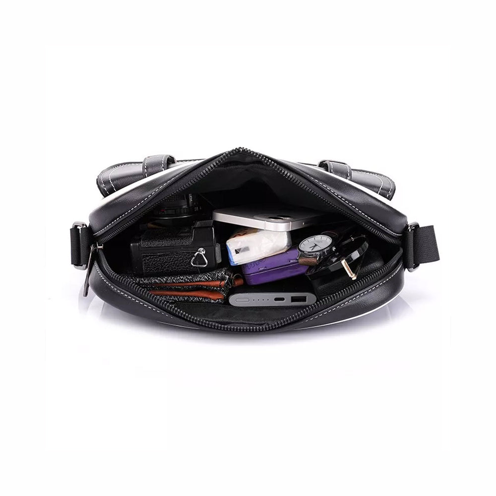 Classic crossbody bag in black with a monogram print, open and packed with cables, a charger, keys and a phone