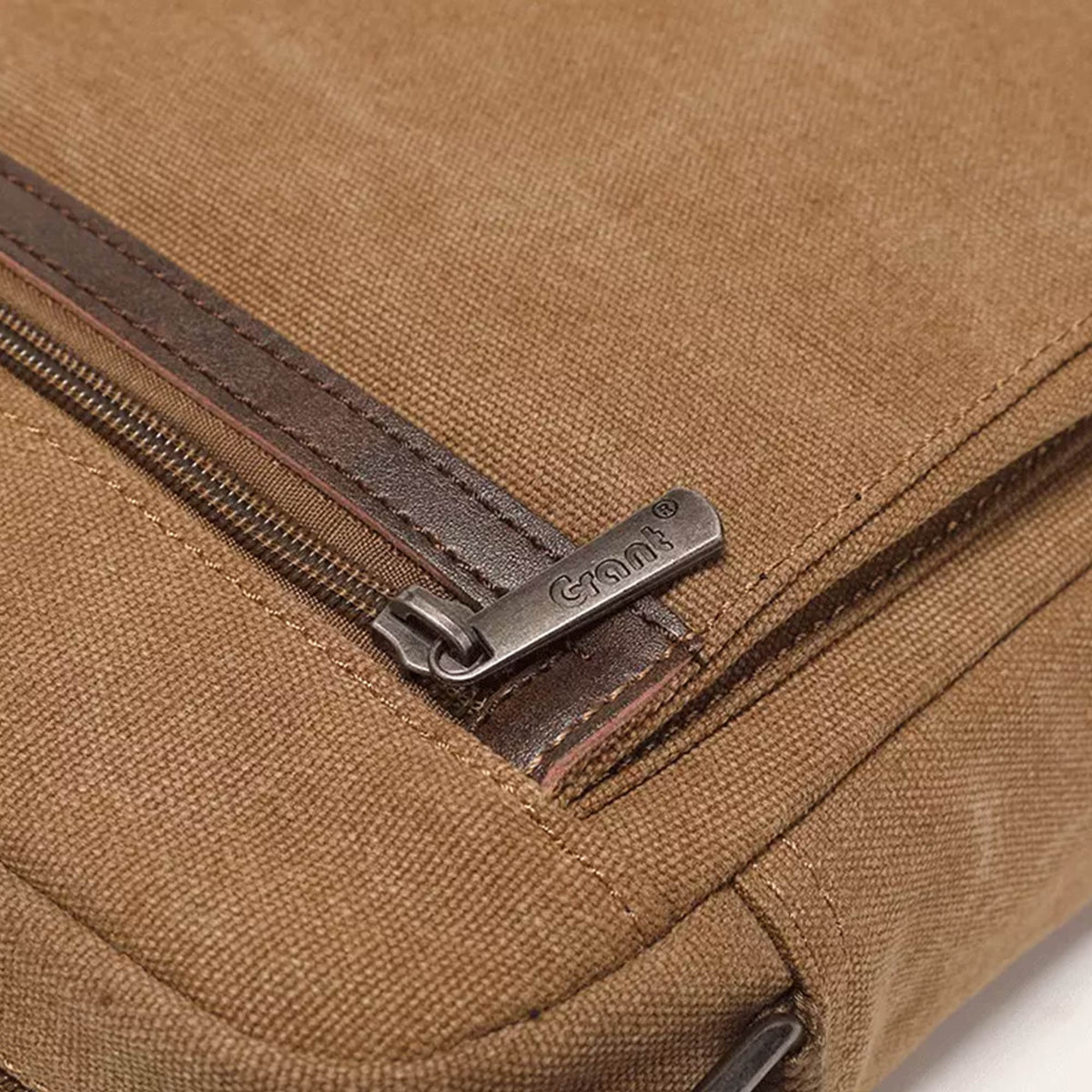 Close-up of the top zip and leather trim on the Grant canvas crossbody bag
