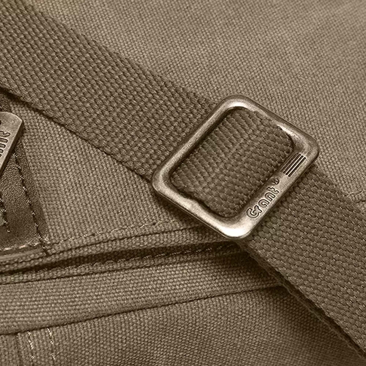 Close-up of the strap slider on the olive Grant canvas crossbody bag