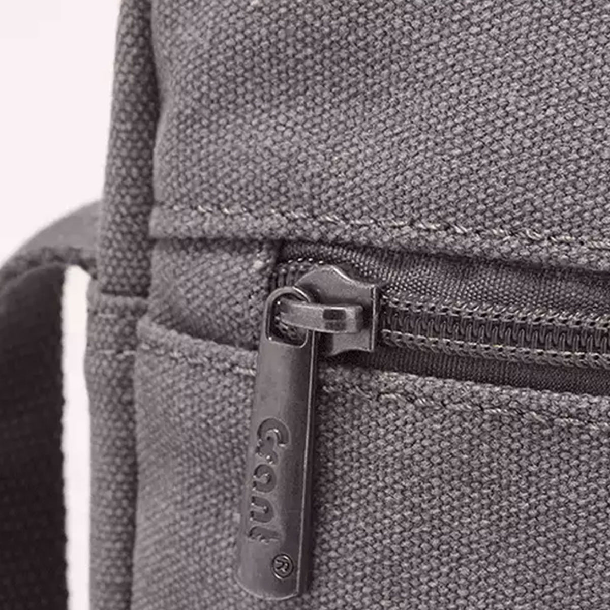 Close-up of the double zip pockets on the grey Grant canvas crossbody bag