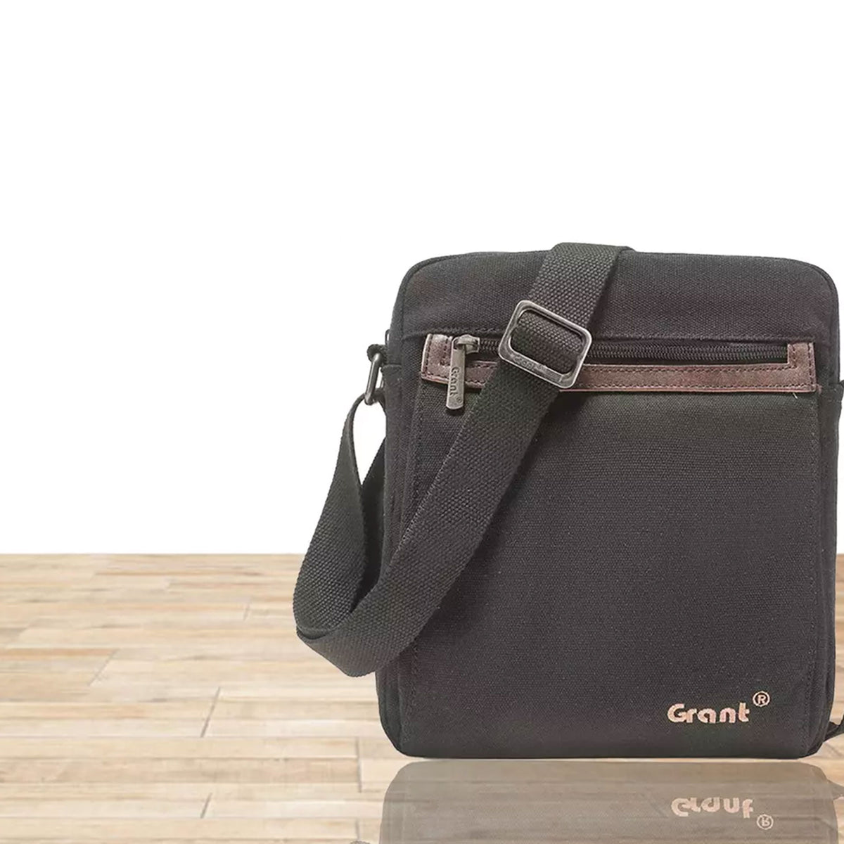 Grant compact canvas crossbody bag in dark olive canvas, front view on a wooden floor