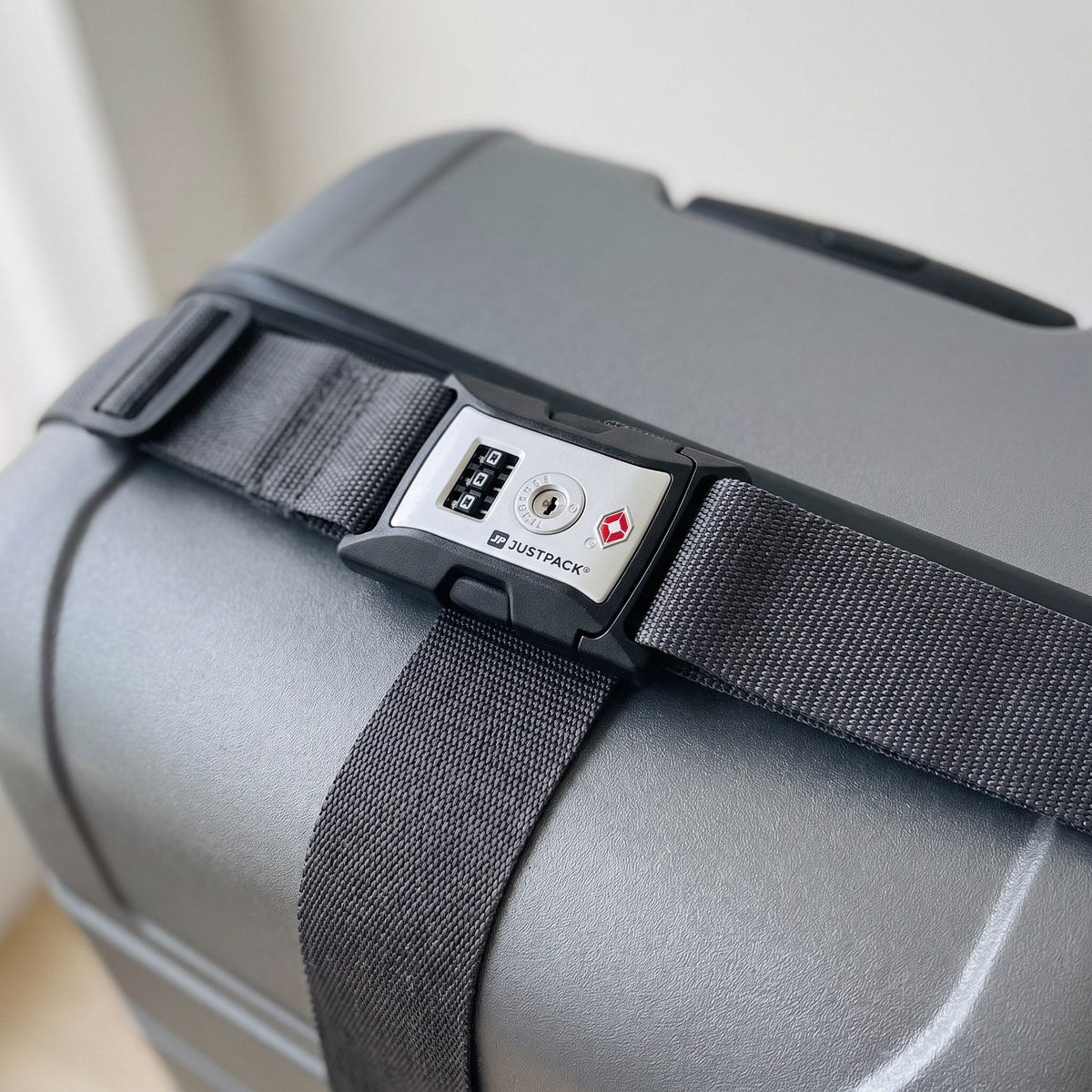 JUSTPACK Cinch luggage strap with TSA lock in charcoal grey, secured around luggage