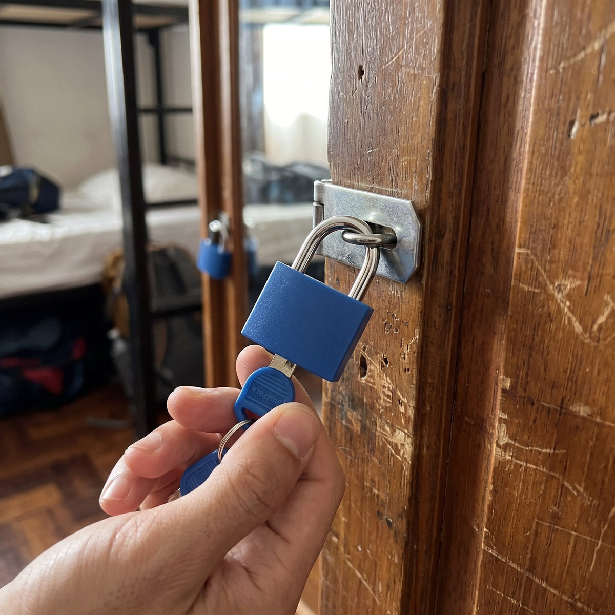 JUSTPACK Beacon keyed travel padlocks (2-pack) in blue, locking a hostel locker