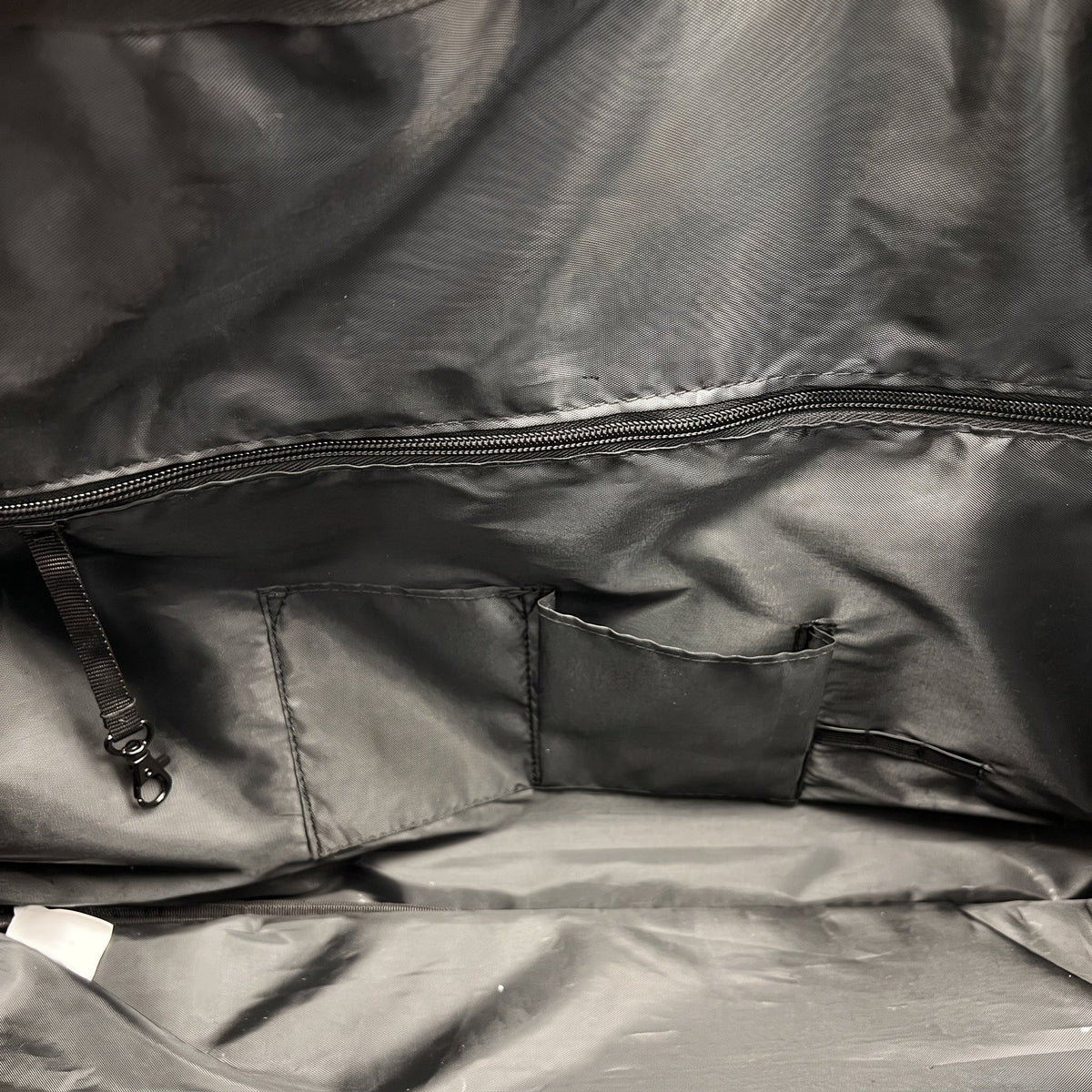 The zipped interior pocket on the lining of the JUSTPACK Belgrave wheeled holdall in black faux leather